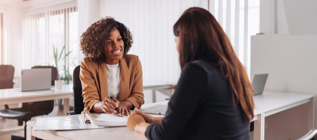 Two women reviewing papers together at desk