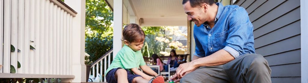 Dad sitting on porch playing with son