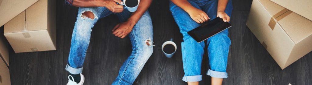 Woman and man looking at tablet while they sit on the floor