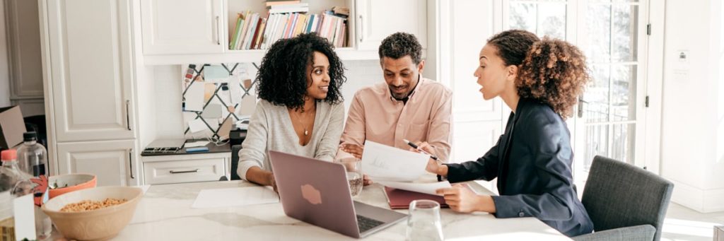 Couple reviewing paperwork with a lady