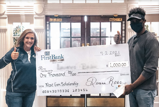 Loan officer presenting check to NextGeneration Scholarship recipient