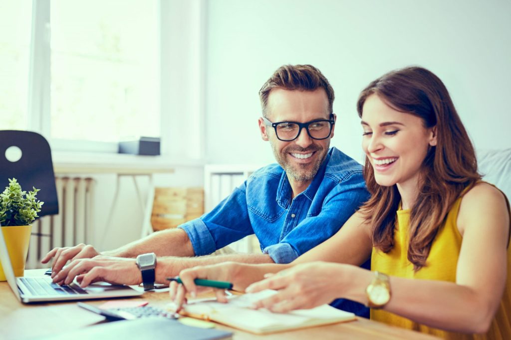 Couple working together at desk and smiling