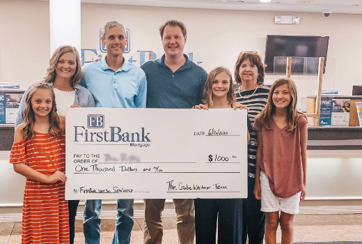Loan officer presenting check to NextGeneration Scholarship recipient