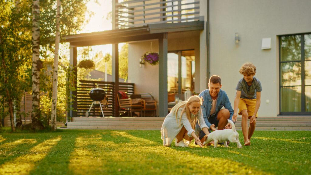 Family playing in yard in front of house