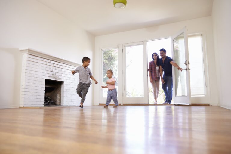 Family walking into empty living room on moving day